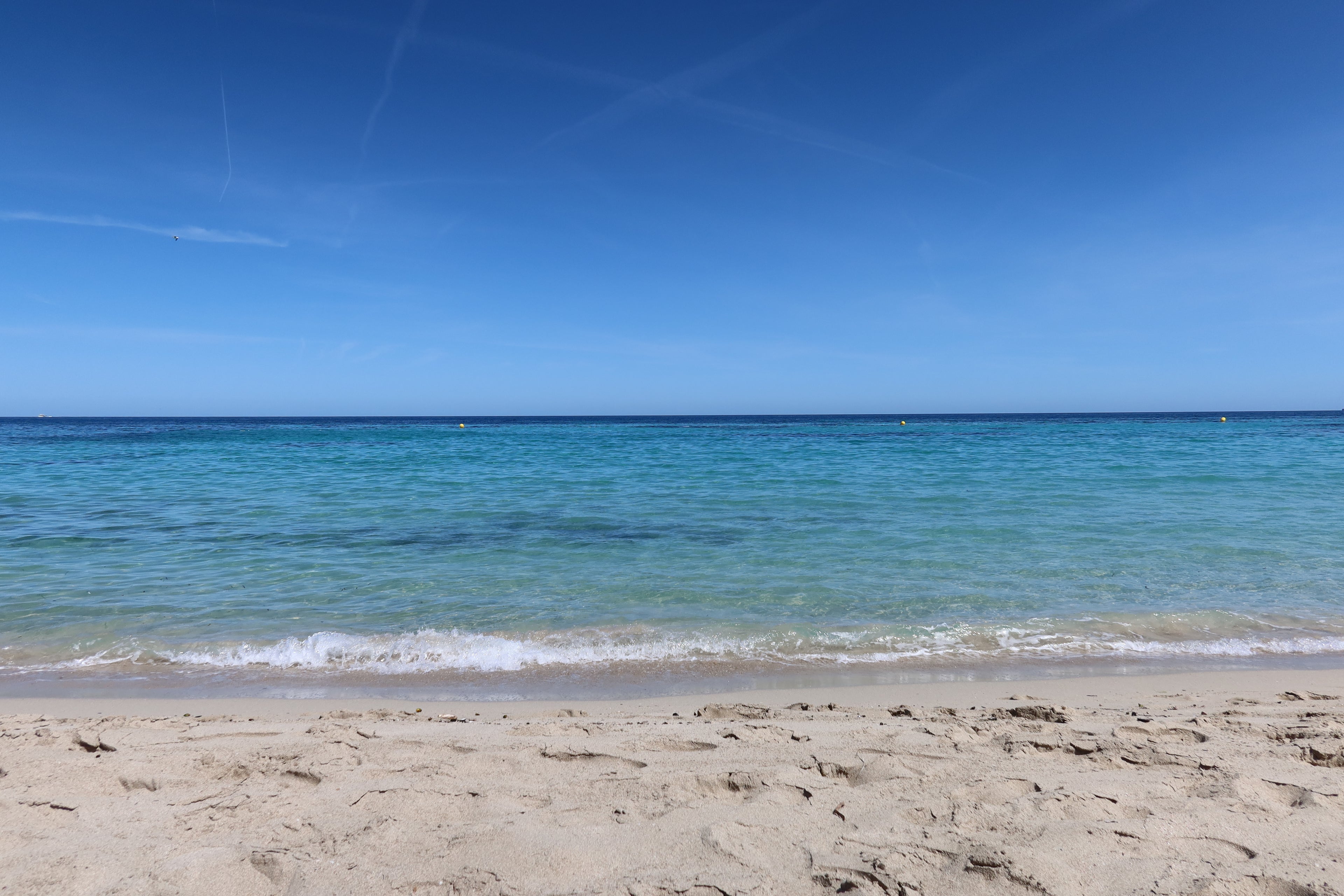 Beach with soft sand and calm blue waves, used for Soline Atelier coming soon page